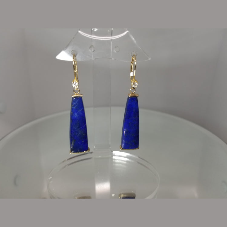 Beautiful 14k yellow gold earrings with a vibrant blue lapis stone. They each feature a brilliant cut diamond at the top and dangle by yellow gold lever backs. 