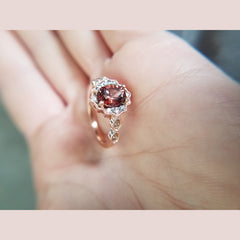 A beautifully made rose gold and zircon ring. This custom piece features a 2.13ct oval zircon, surrounded by 12 diamonds. This ring is a size 7.
