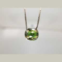 This custom 14k white gold and 18k yellow gold pendant that features a 1.32ct oval peridot is the perfect piece  to dress up any outfit. It hangs beautifully on am 18" white gold box chain. 