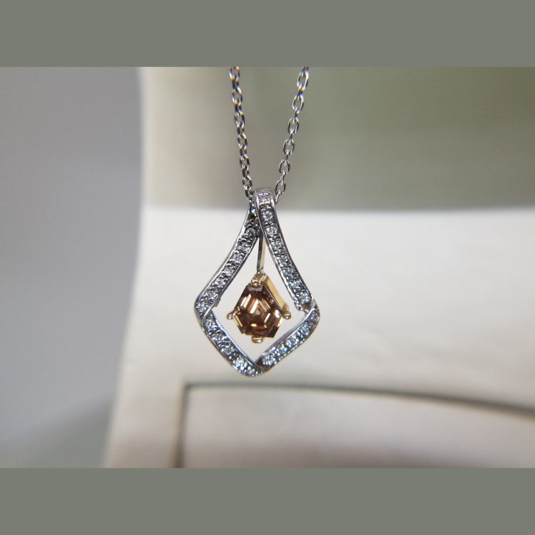 A stunning custom pendant! This pendant features a 1.10 cognac kite diamond, in a rose gold dangling head. Surrounding the floating cognac diamond are 0.13ct of diamonds. 