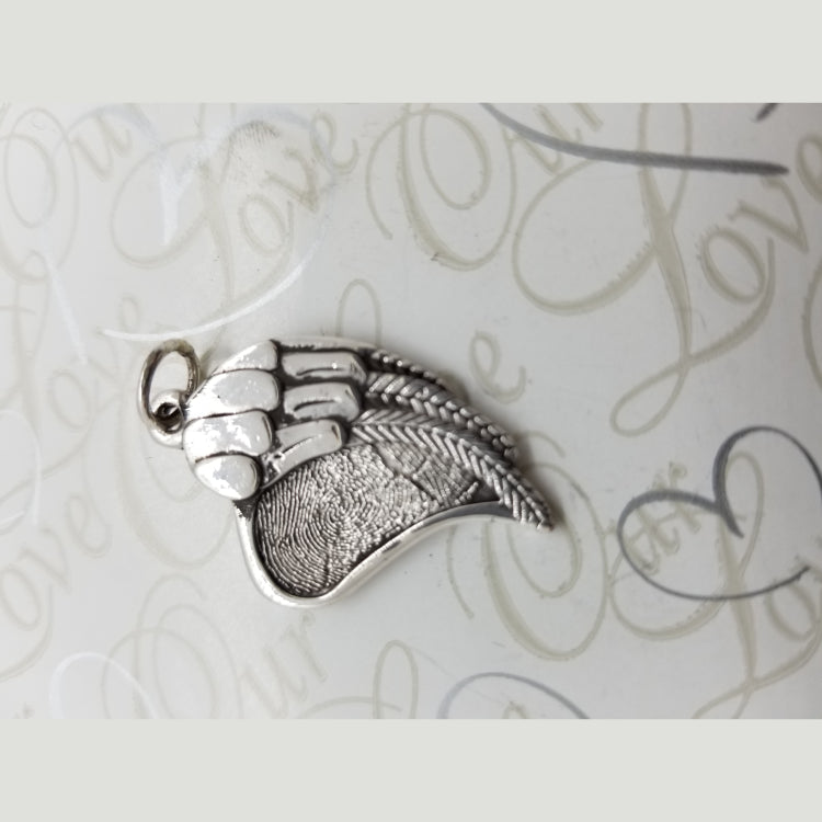 This custom pendant features an angel wing on half and a fingerprint heart on the other half. Two sizes 18mm and 28mm. 