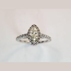 Custom diamond engagement ring. The ring features a 0.64ct marquise center diamond with accent diamonds in a halo, and on the shank. Total diamond weight of 0.98ct